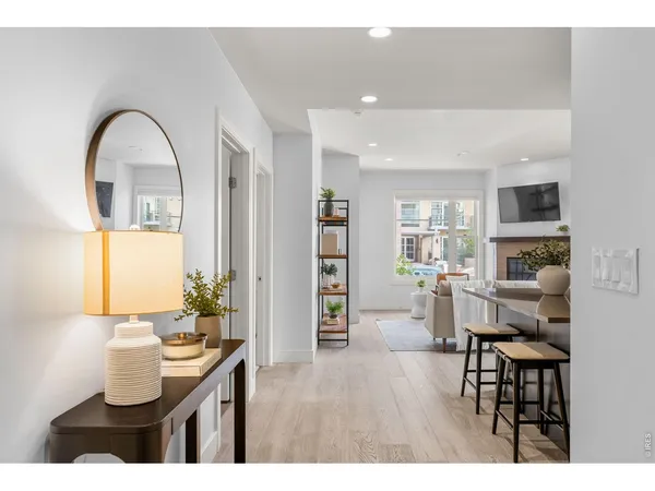 a kitchen with stainless steel appliances kitchen island granite countertop a refrigerator a stove a sink a dining table and chairs with wooden floor