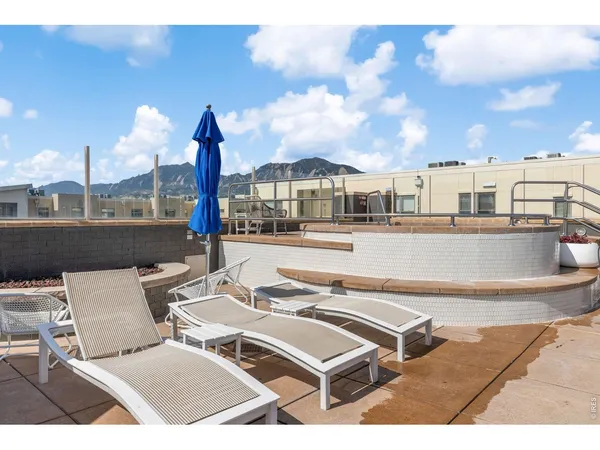 a view of building with a yard and a car park in front of it