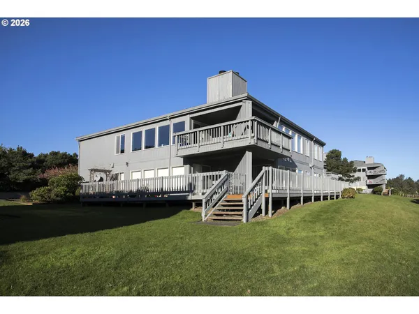 a view of a house with a big yard and a deck