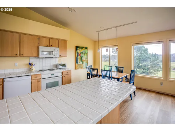 a kitchen that has a lot of cabinets a sink and a wooden floor