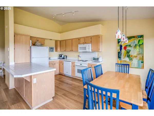 a open kitchen with stainless steel appliances a stove a refrigerator a dining table and chairs