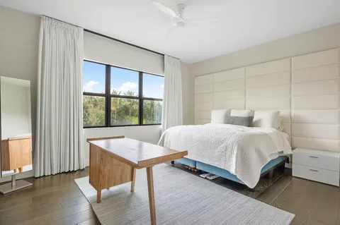 a bedroom with a bed and a large window