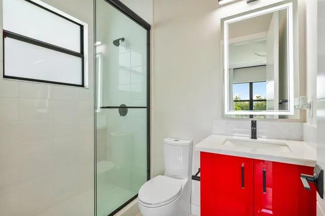 a bathroom with a sink a toilet and shower