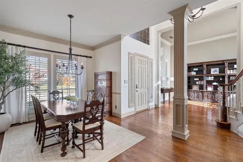 a dining room with furniture water chandelier and wooden floor