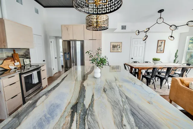 a view of a dining room with furniture a chandelier and wooden floor