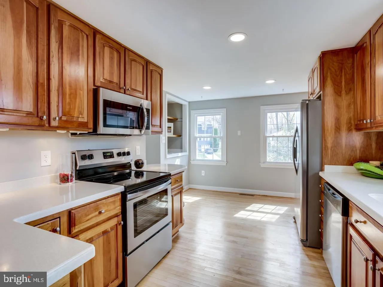 6502 Shipyard Place Falls Church, VA 22043 - Photo 4 of 19 a kitchen with stainless steel appliances granite countertop wooden cabinets a stove a sink and a refrigerator