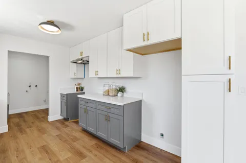 a kitchen with a sink cabinets and wooden floor