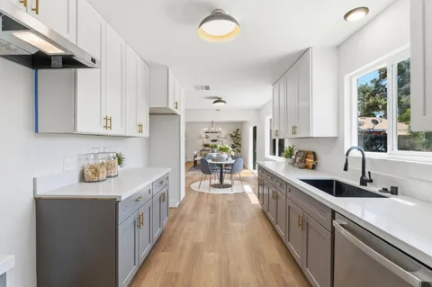 a kitchen with stainless steel appliances sink cabinets and window