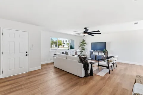 a living room with furniture and a wooden floor
