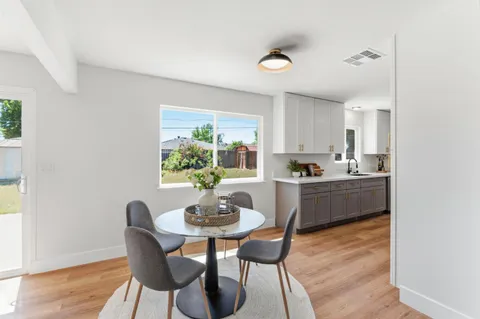 a kitchen with a dining table chairs and window