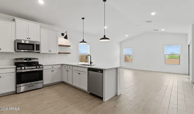 a kitchen with stainless steel appliances granite countertop a stove a sink and a refrigerator