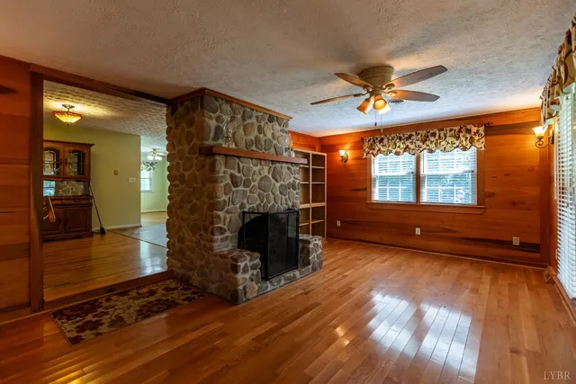 a view of empty room with wooden floor and fireplace
