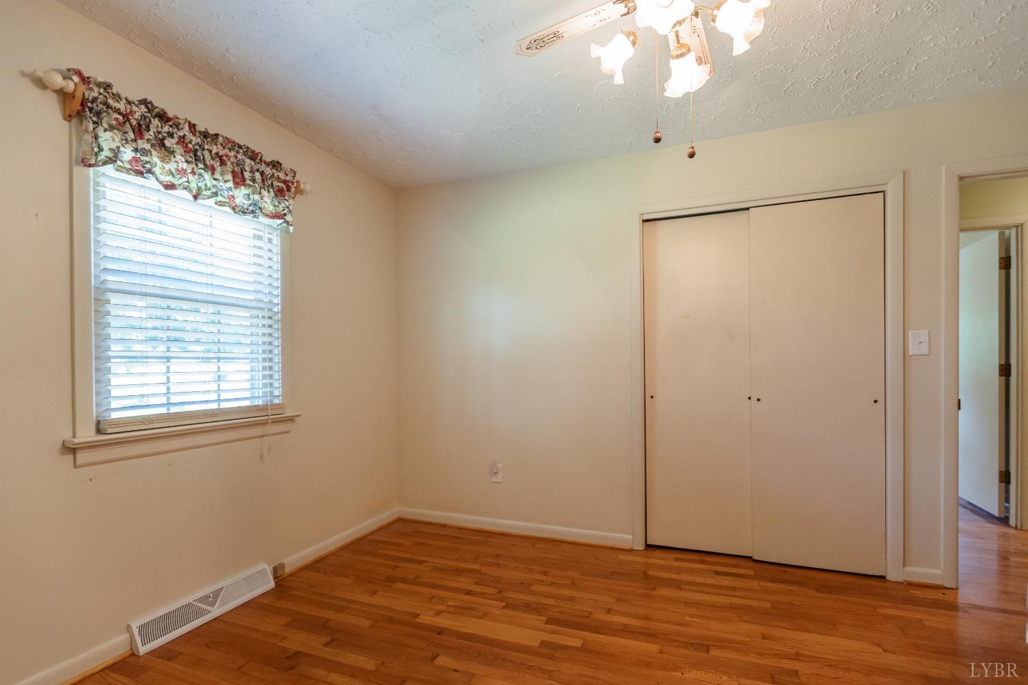 1338 Wickliffe Road Brookneal, VA 24528 - Photo 13 of 24 an empty room with wooden floor and windows