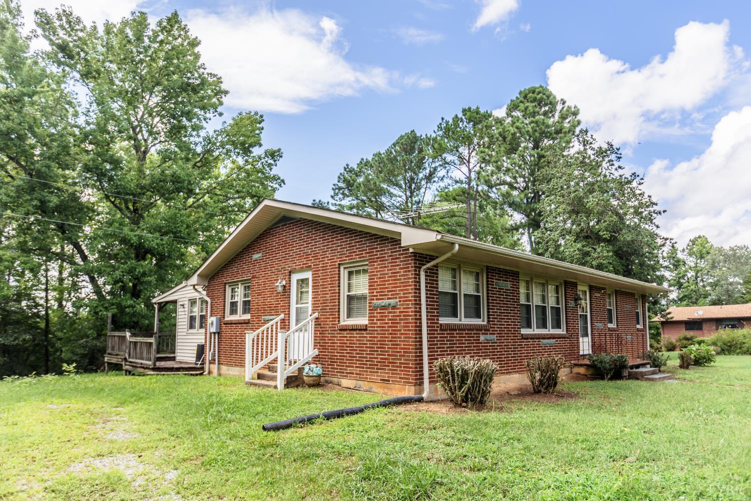 1338 Wickliffe Road Brookneal, VA 24528 - Photo 2 of 24 a view of a yard in front of a house with large windows