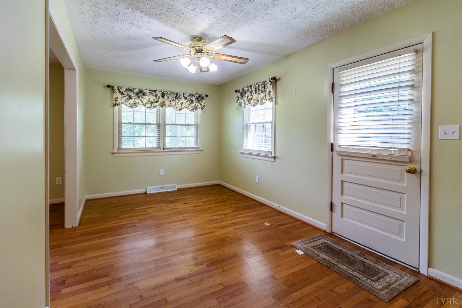 1338 Wickliffe Road Brookneal, VA 24528 - Photo 5 of 24 a view of an empty room with a window and wooden floor