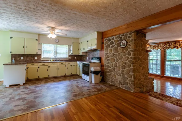 a view of a kitchen with a sink wooden cabinets and a window