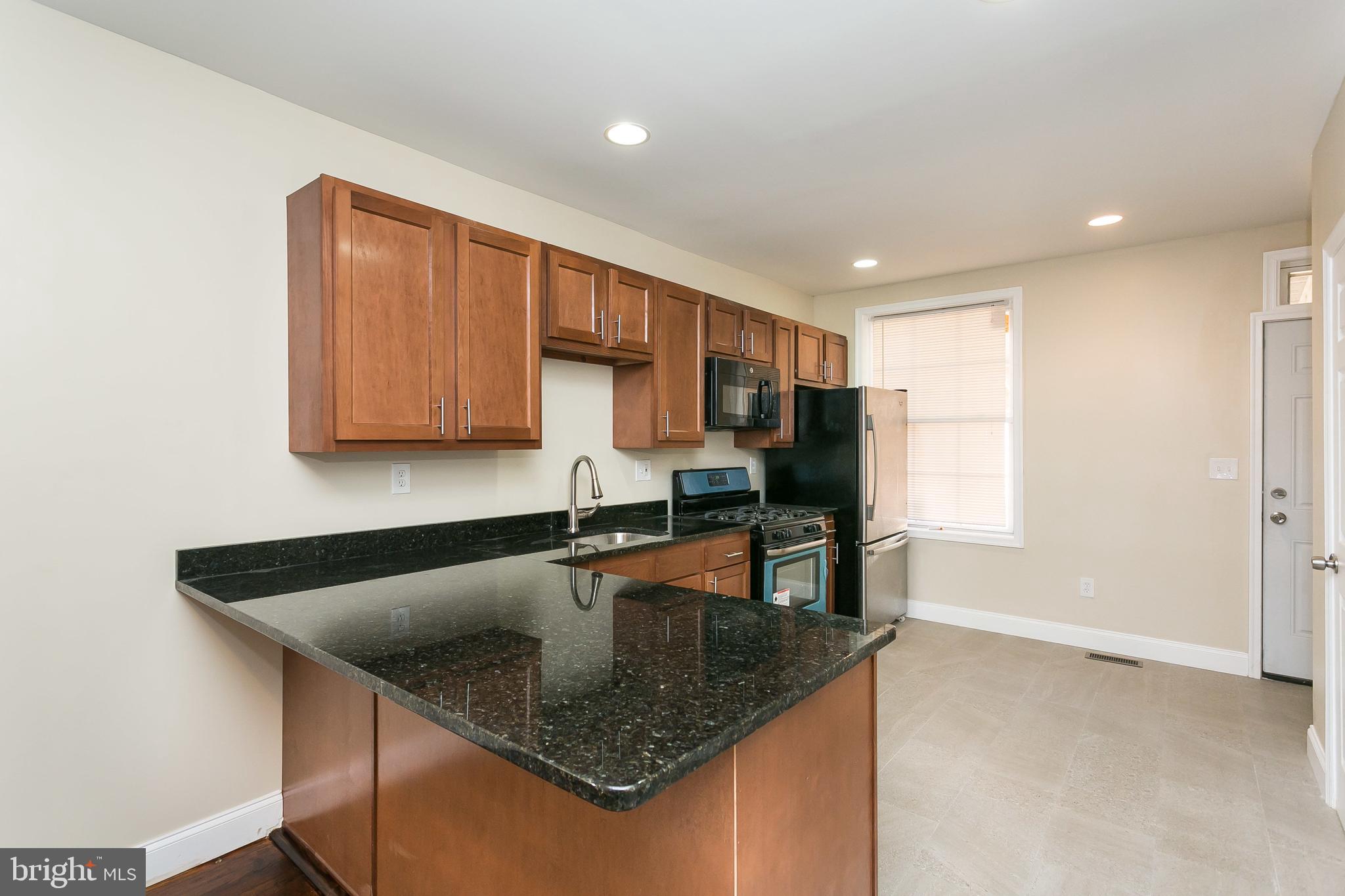302 East 27th Street Baltimore, MD 21218 - Photo 8 of 31 Updated large kitchen leads to back patio