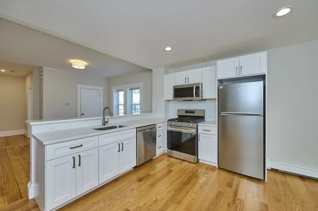 a kitchen with white cabinets and stainless steel appliances