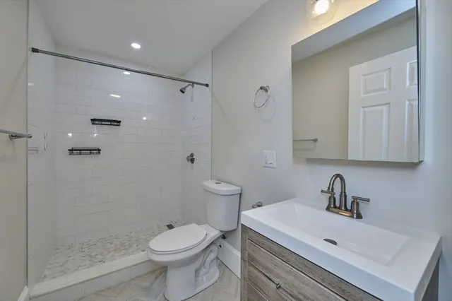 a bathroom with a sink a toilet and shower