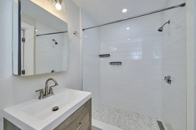 a bathroom with a sink mirror and shower