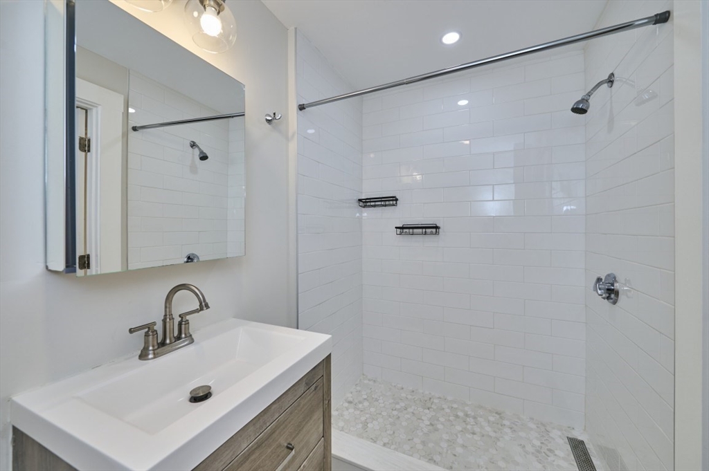 67 Wheatland Street, Unit 2 Somerville, MA 02145 - Photo 15 of 19 a bathroom with a sink mirror and shower
