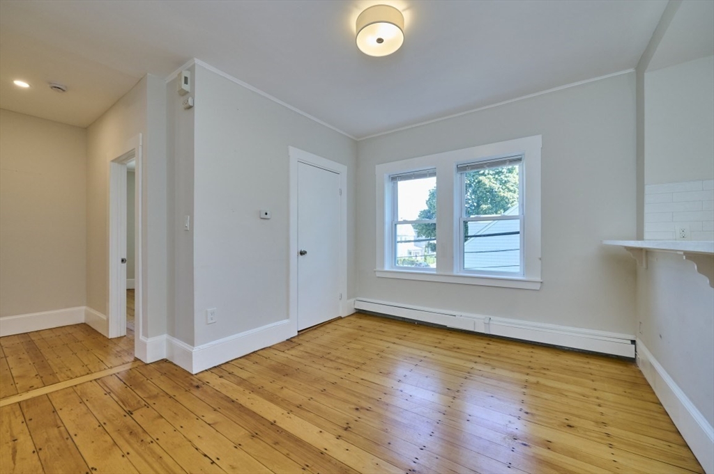 67 Wheatland Street, Unit 2 Somerville, MA 02145 - Photo 5 of 19 a view of an empty room with wooden floor and a window