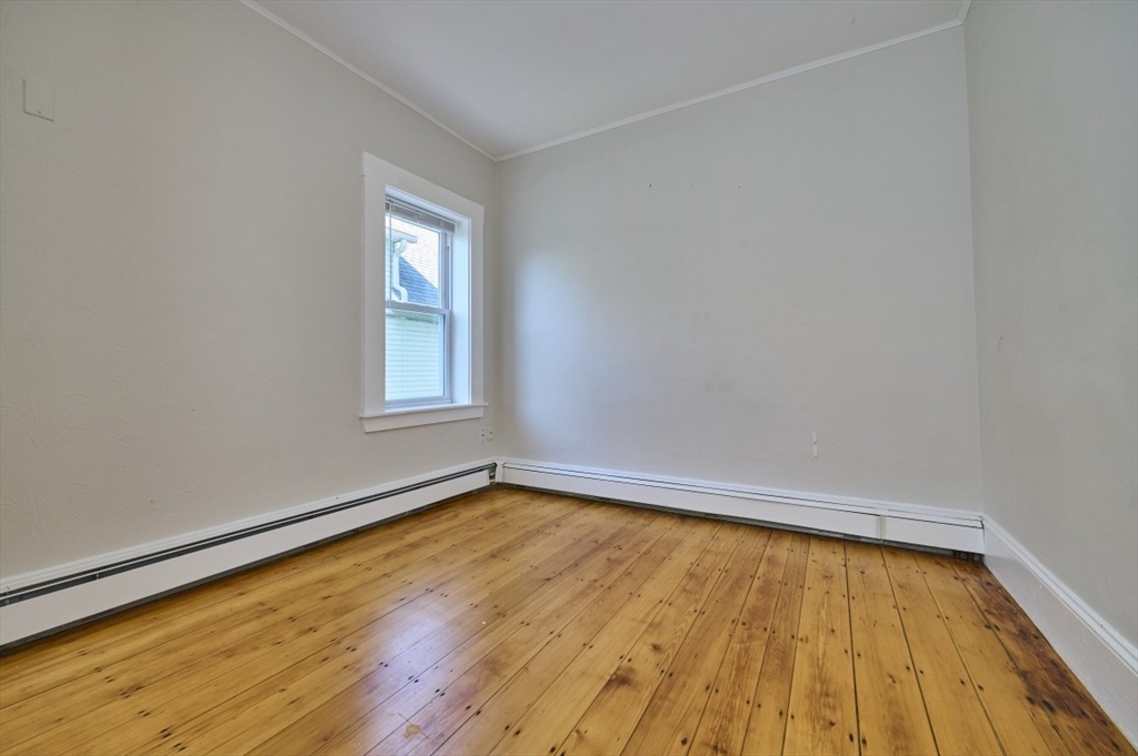 67 Wheatland Street, Unit 2 Somerville, MA 02145 - Photo 9 of 19 an empty room with wooden floor and windows