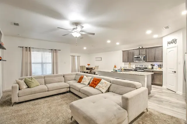 a living room with furniture and kitchen view