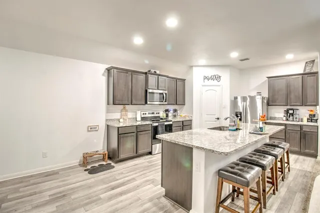 a kitchen with a sink a stove a refrigerator and a oven