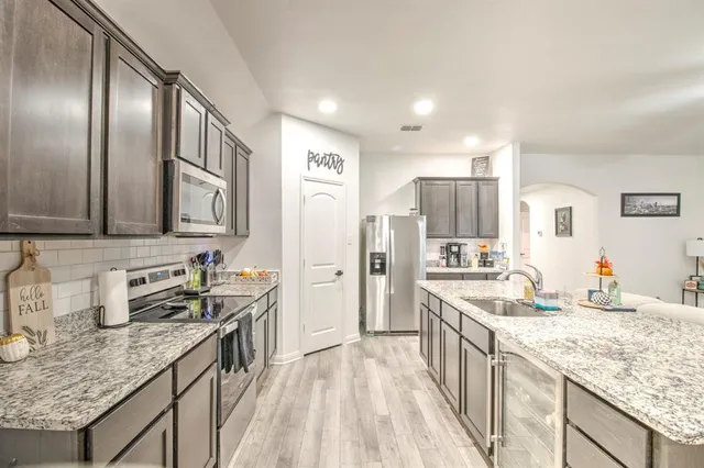 a kitchen with stainless steel appliances granite countertop a sink stove and refrigerator