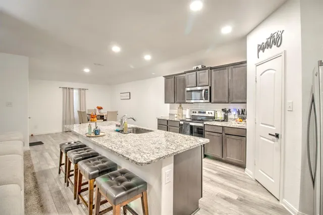 a kitchen with stainless steel appliances granite countertop a sink stove and refrigerator