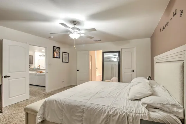 a spacious bedroom with a bed and a chandelier