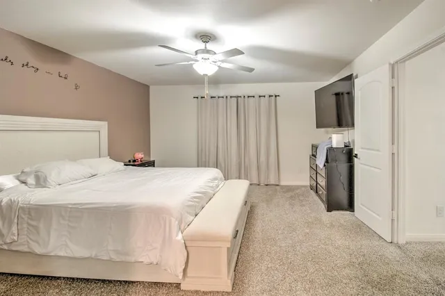 a bedroom with a large bed and a chandelier