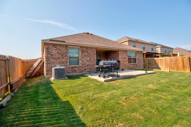 a view of a house with a backyard and a patio