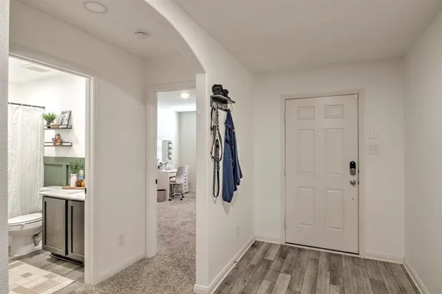 a view of a hallway with bathroom and wooden floor
