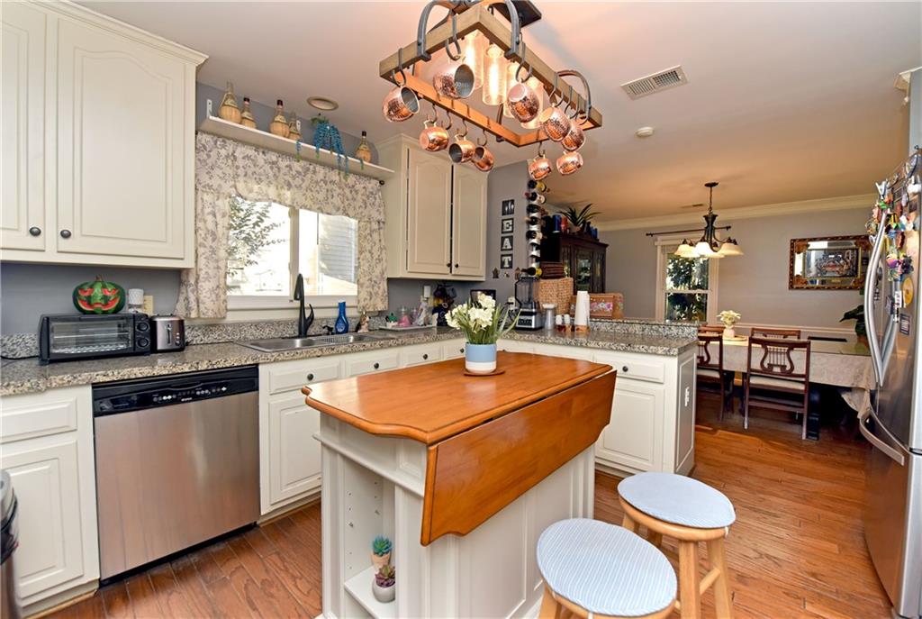 107 East Clinton Drive Southwest Rome, GA 30165 - Photo 11 of 38 a kitchen with a dining table chairs sink and cabinets
