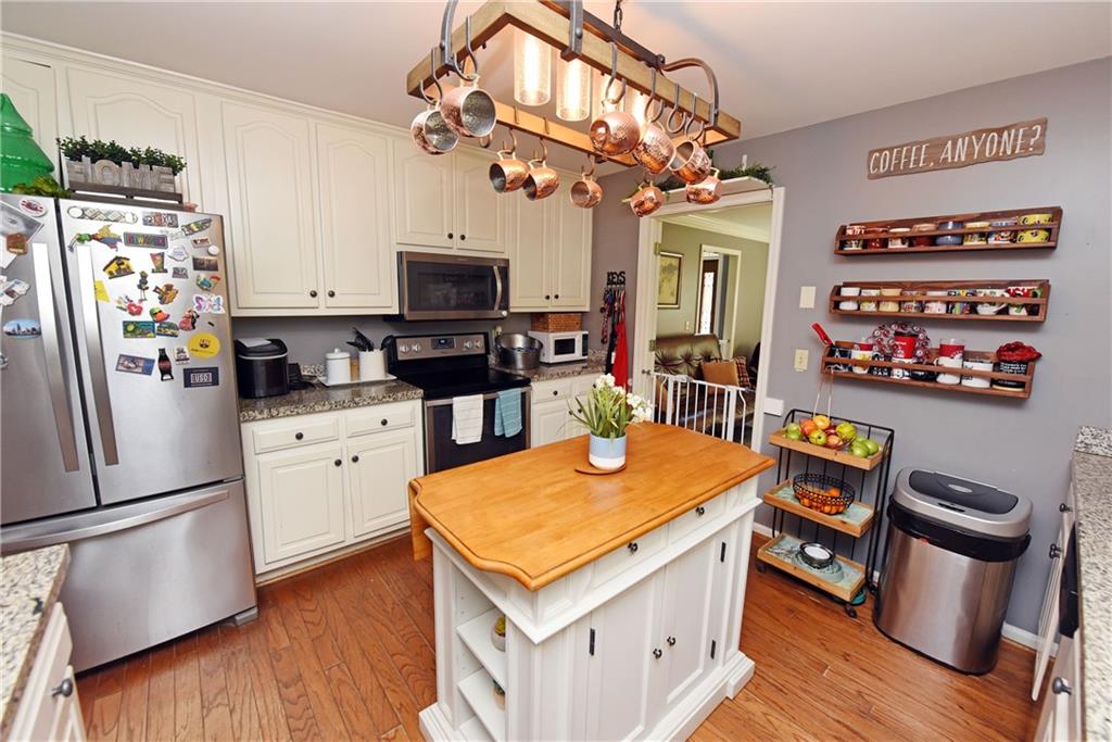107 East Clinton Drive Southwest Rome, GA 30165 - Photo 12 of 38 a kitchen with stainless steel appliances granite countertop a refrigerator a stove top oven a sink dishwasher and white cabinets with wooden floor