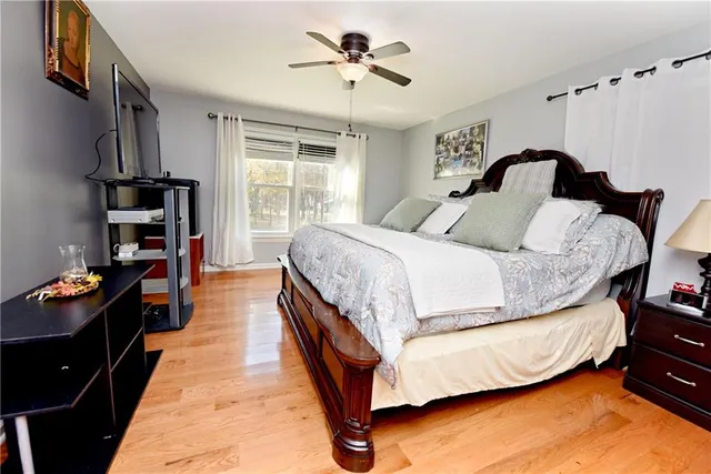 a bedroom with a bed and a flat tv screen on dresser