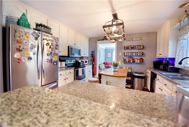 a kitchen with stainless steel appliances granite countertop a refrigerator and a stove top oven