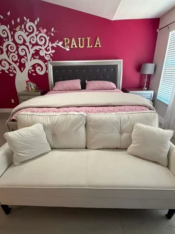 a bedroom with a bed and a large mirror with a ceiling fan