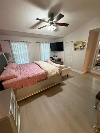 a white toilet sitting next to a wooden floor