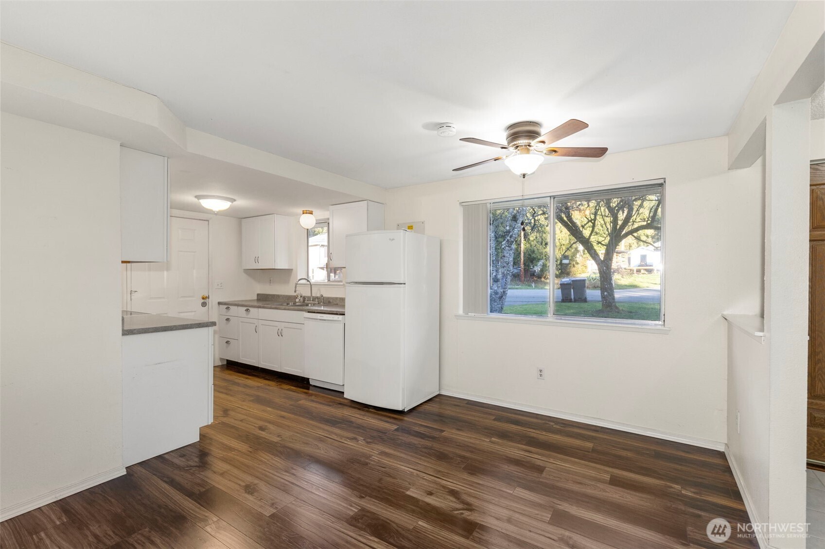 7606 Sandy Way Northeast Poulsbo, WA 98370 - Photo 5 of 20 a view of a kitchen with wooden floor and a ceiling fan