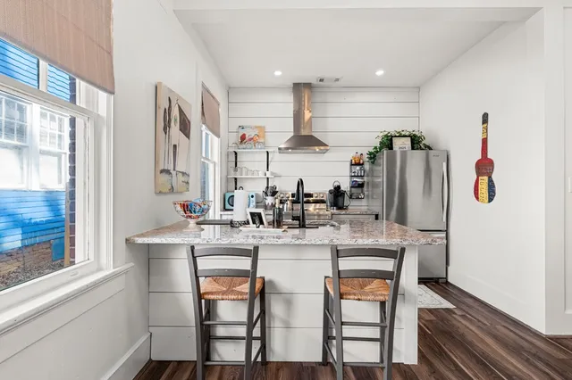 a kitchen with stainless steel appliances granite countertop a table chairs stove and refrigerator