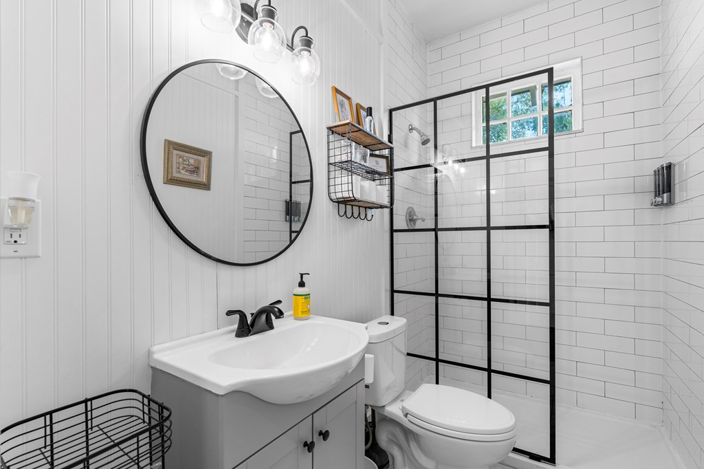 820 2nd Avenue Columbus, GA 31901 - Photo 17 of 28 a bathroom with a sink a mirror a toilet and a shower