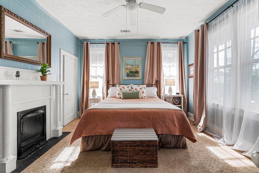 820 2nd Avenue Columbus, GA 31901 - Photo 21 of 28 a spacious bedroom with a bed a fireplace and a chandelier