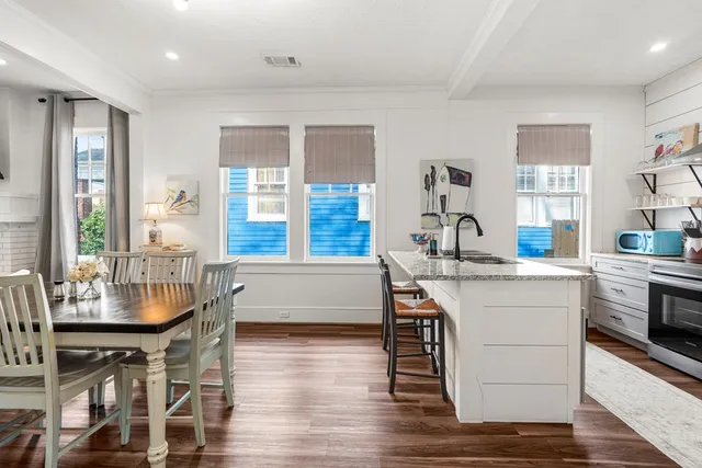 a kitchen with a table chairs stove and wooden floor