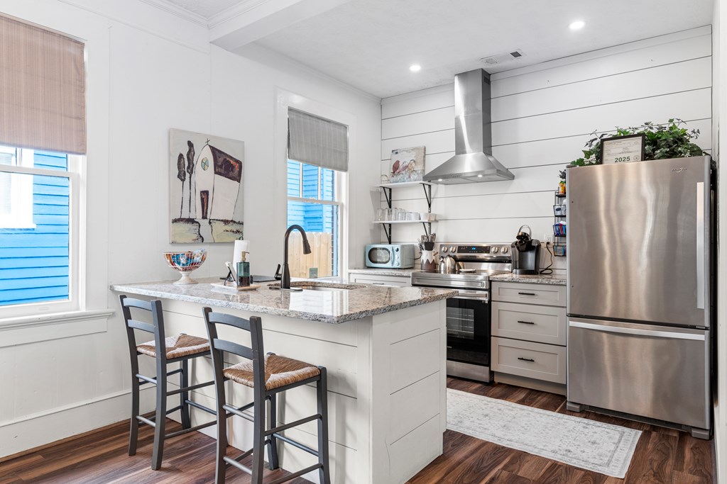 820 2nd Avenue Columbus, GA 31901 - Photo 10 of 28 a kitchen with stainless steel appliances a white refrigerator a sink dishwasher a dining table and chairs with wooden floor