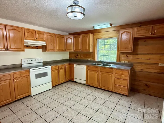 a kitchen with a sink a stove top oven and cabinets