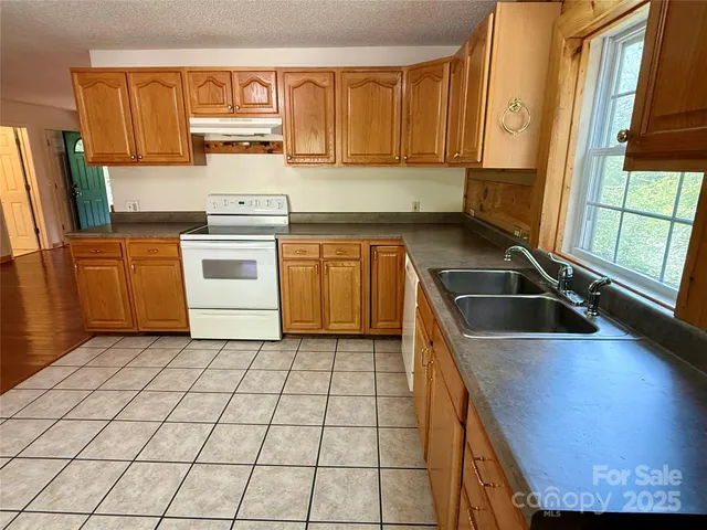 a kitchen with a stove a sink and cabinets