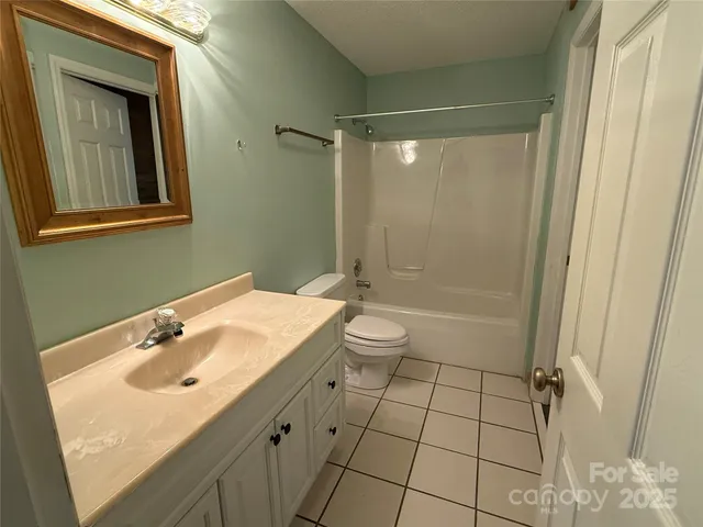 a bathroom with a toilet a sink a vanity and mirror